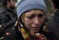 A woman cries as refugees and migrants protest in front of the border gate that separates Greece from Macedonia near the ...