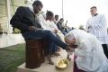 Pope Francis kisses the foot of a man during the foot-washing ritual at the Castelnuovo di Porto refugee centre near ...