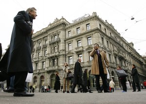 People pass in front of the Credit Suisse headquarters in Zurich, Switzerland, Thursday, Oct. 22, 2009. Credit Suisse Group reported a 2.4 billion Swiss franc (Euro 1.9 billion, $2.4 billion) net income during the third quarter as it continued strengthening its position following losses caused by the economic crisis.