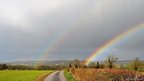 Double Rainbow over fields and country lane 