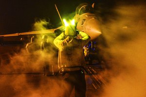 File - A U.S. Navy seaman directs an E/A-18G Growler to the catapult on the flight deck of the aircraft carrier USS Theodore Roosevelt in the U.S. 5th fleet area of operations, May 28, 2015.