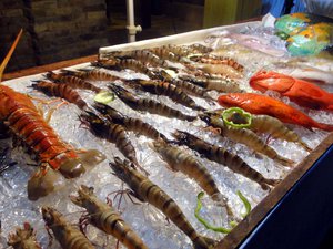 Fresh shrimps, lobsters, and fishes are placed on top of crushed ice, ready to be cooked on request.