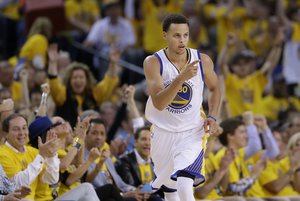 Golden State Warriors guard Stephen Curry (30) reacts after scoring against the Memphis Grizzlies during the first half of Game 1 in a second-round NBA playoff basketball series in Oakland, Calif., Sunday, May 3, 2015