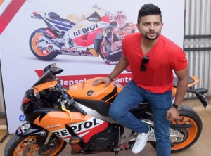 Indian cricketer Suresh Raina posing with a sportsbike at a press conference of GP Petroleums...