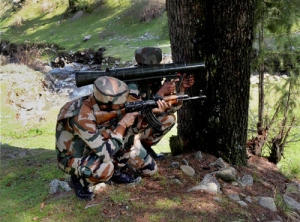 Army personnel take position at the site where militants were hiding during an encounter at...