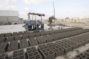 Palestinian labourers work at a cement factory in Khan Yunis in the southern Gaza Strip on August 02, 2010. Palestinians destroy cement blocks gathered from destroyed houses before recycling them to use them in new construction. ( Photo by Ahmed Deeb/WN)