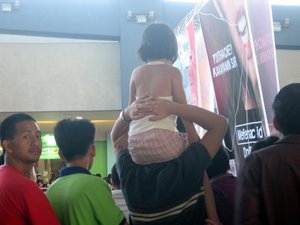 A baby girl was being load up to the shoulder of his father to see the entertainment show, Wed, January, 28, 2009