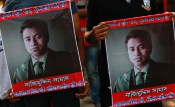 People carry portraits of student activist Nazimuddin Samad as they attend a rally to demand arrest of three motorcycle-riding assailants who hacked and shot Samad to death