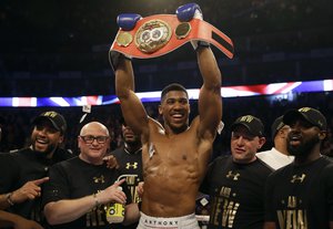 British boxer Anthony Joshua celebrates after winning the IBF heavyweight title bout between US boxer Charles Martin and British boxer Anthony Joshua