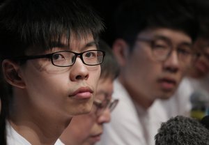 Hong Kong teen activist Joshua Wong, left, and members of their new political party Demosisto listen to reporter's questions as their party officially unveiled during a press conference in Hong Kong, Sunday, April 10, 2016.