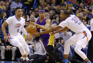 Los Angeles Lakers guard Jordan Clarkson (6) is stopped by Oklahoma City Thunder guard Russell Westbrook (0) and Oklahoma City Thunder forward Kevin Durant (35) during the second half of an NBA basketball game in Oklahoma City, Monday, April 11, 2016. Oklahoma City won 112-79.