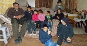 Friend Nuredin Amro and his son, Abedkarim sit on the far left side. Seven of the children who live in this house are, from left to right: Mira, Mayaan, Ahmad, Yara. On top, Fajer. On the floor, Mohammad and Badar.