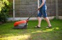 mature woman mowing the garden lawn