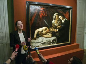 Julie Ducher, French expert specialized in old master paintings, talks to the media in Paris, Tuesday, April 12, 2016 next to a painting that might have been executed by Italian master Caravaggio.