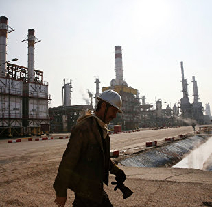 An Iranian oil worker makes his way through Tehran's oil refinery south of the capital Tehran, Iran, Monday, Dec. 22, 2014