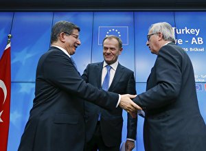 Turkish Prime Minister Ahmet Davutoglu (L), European Council President Donald Tusk (C) and European Commission President Jean Claude Juncker (R) greet each other after a news conference at the end of a EU-Turkey summit in Brussels March 8, 2016