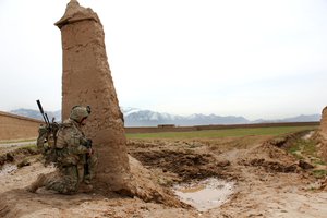 File - A Georgian soldier takes a knee while providing security during a patrol outside of the Qaleh Musa Pain village in Helmand province, Afghanistan, March 12, 2015.