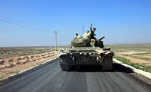 Syrian pro-government forces advance on a road through the town of Khanasser, which is the sole link between government-held areas in and around Aleppo and those in the rest of the country, after they reportedly recaptured it from Islamic State (IS) group fighters, on February 29, 2016.