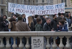 People gather next to a banner which reads, "citizen, let's write ourselves the next constitution"on the Place de la Republique, in Paris, France, Wednesday, April 13, 2016.