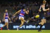 Jason Johannisen of the Bulldogs kicks, only to end up injuring his hamstring.