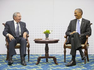 US President Barack Obama, right, smiles as he looks over towards Cuban President Raul Castro