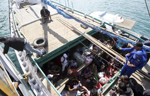 In this May 12, 2013 file photo, Iranian asylum seekers who were caught in Indonesian waters while sailing to Australia, sit on a boat, at Benoa port in Bali, Indonesia.