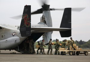 Japan's Ground Self Defense Force and U.S. military members load relief goods onto MV-22 Osprey which arrived in their Takayubaru vice camp in earthquake-hit Mashiki, Kumamoto prefecture, southern Japan, April 18, 2016. U.S. airlifts were delivering water, bread, ready-to-eat food and other emergency supplies Monday to a remote area of southern Japan stricken by two powerful earthquakes, as local rescuers searched for 10 people still reported missing. (Koji Ueda/AP Photo)