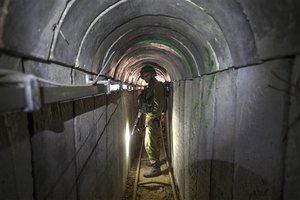 An Israeli army officer gives journalists a tour, Friday, July 25, 2014, of a tunnel allegedly used by Palestinian militants for cross-border attacks, at the Israel-Gaza Border.