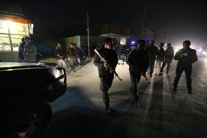 Afghan security forces inspect the site of an explosion in Kabul, Afghanistan, Friday, Jan. 1, 2016.