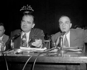 Sen. Joe McCarthy sits in the witness chair at the close of the June 11, 1954 proceedings in the Senate hearings on his dispute with the Army, as Roy Cohn breaks in to ask for a 10-minute round of questioning McCarthy.