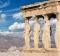 The statues of Erechtheion on Acropolis and the town in morning light.