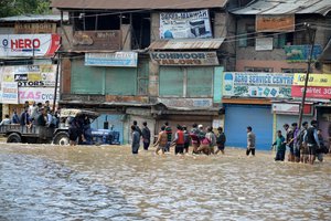 File - File - People cling to trucks and wade through water as they are moved to safety following flooding in Anantnag district, Kashmir, 25 June, 2015.