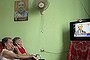 Retired airplane painter Ernesto Arias, 78,  (L), and accountant Carola Suarez, 81, sit under a picture of former Cuban president Fidel Castro to watch U.S. President Barack Obama's statement about Cuba on television, at the Eterna Juventud (Eternal Youth) retirement home in Havana, Cuba July 1, 2015. Obama said on Wednesday the United States had agreed to the historic step of re-establishing diplomatic relations with Cuba and will raise its flag over a U.S. Embassy in Havana later this summer. REUTERS/Alexandre Meneghini       TPX IMAGES OF THE DAY