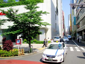 White taxis wait for their turn to cross the street in Tokyo, Japan.