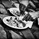 Afghan immigrant in Paris eating a meal from the Red Cross on the street