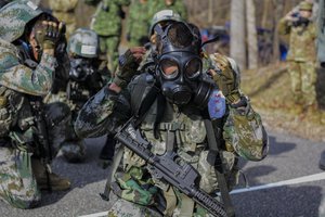 File - A Chinese army cadet puts on a protective mask at the chemical, biological, radiological and nuclear station during the 2016 Sandhurst Competition at West Point, N.Y., April 9, 2016.