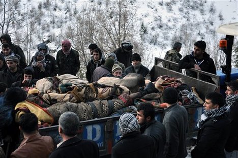 In this Thursday, Dec. 29, 2011 photo, people stand beside the trailer of a tractor carrying the bodies of people mistakenly killed by Turkey's air force, near the Turkish village of Ortasu in Sirnak, Turkey.