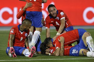 Chile's Alexis Sanchez, center right, top, embraces a teammate as he celebrates his goal against Bolivia during a Copa America Group A soccer match at El Nacional stadium in Santiago, Chile, Friday, June 19, 2015.