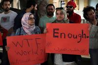 Protesters hold placards during a protest in downtown Beirut April 30, 2016, against Syrian President Bashar Assad's military operations against areas held by insurgents. The Arabic placard read: "Enough, Aleppo is burning." Bilal Hussein/AP