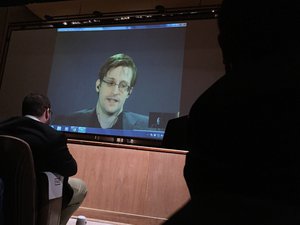 Former National Security Agency contractor Edward Snowden, center speaks via video conference to people in the Johns Hopkins University auditorium, Wednesday, Feb. 17, 2016, in Baltimore.