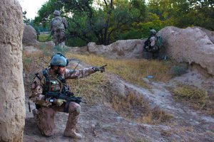 File - A Czech soldier points in the direction of movement as U.S. and Afghan soldiers patrol through a village in Parwan province, Afghanistan, Oct. 20, 2015.