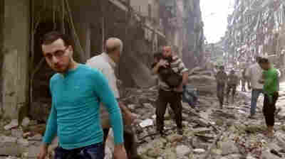 A man carries a child after airstrikes hit Aleppo, Syria last month.