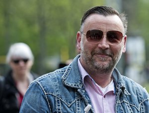 Lutz Bachmann, co-founder of Germany's PEGIDA movement, smiles between his supporters prior to the beginning of his trial on accusations of incitement in Dresden, eastern Germany, Tuesday, May 3, 2016.