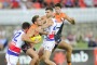 Western Bulldogs players Kieran Collins and Koby Stevens tackle GWS Giants player Stephen Coniglio as team mate Jonathon ...