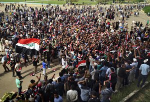 Protesters and supporters of Shiite cleric Muqtada al-Sadr chant slogans calling for governmental reforms as they wave national flags during a sit-in inside Baghdad's highly fortified Green Zone Sunday, May 1, 2016.