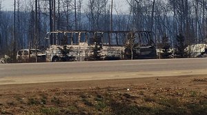 In this Thursday, May 5, 2016 photo provided by the Royal Canadian Mounted Police Alberta, the charred remains of a bus sit on the side of a road in Fort McMurray, Alberta. More than 80,000 people have left Fort McMurray, in the heart of Canada's oil sands as a wildfire that has devastated the area exploded in size.