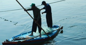 Two fishermen paddle a small boat off the Gaza coast. (Photo by Charlie Andreasson)