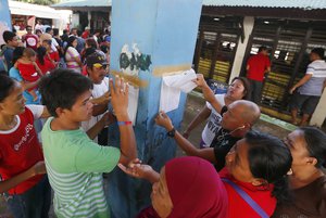 Filipinos check their names outside a polling precinct prior to voting in the country's presidential elections at the front-running presidential candidate Mayor Rodrigo Duterte's hometown of Davao city in southern Philippines Monday, May 9, 2016.