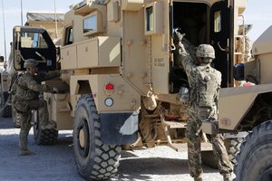 File - U.S. Army Spc. Brandon Russell, right, and Spc. Joseph Sullivan, security force team members for Provincial Reconstruction Team Farah, prepare enter a tactical vehicle prior to departing Forward Operating Base Farah for a meeting with the Farah provincial chief justice in Farah City, May 4, 2013.