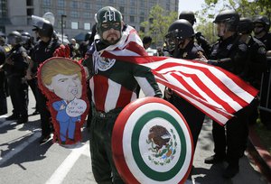 Erik Lopez, dressed as "Captain Mexico", stands in front of police officers while protesting Republican presidential candidate Donald Trump outside of the Hyatt Regency hotel during the California Republican Party 2016 Convention in Burlingame, Calif., Friday, April 29, 2016.